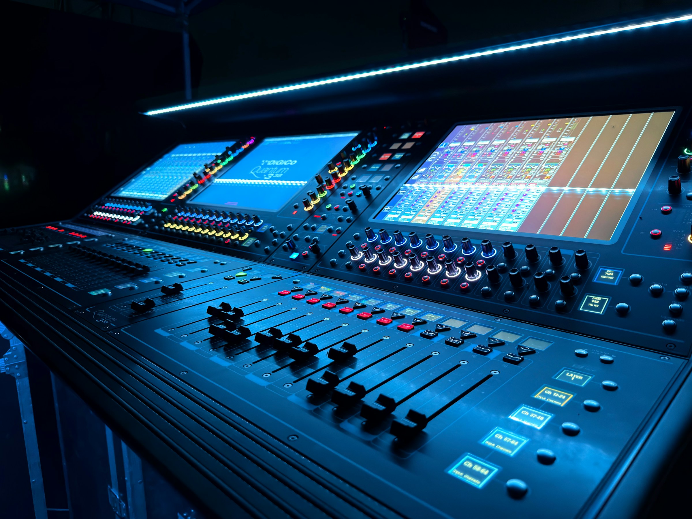 A mixing console and audio control surface in a dark studio