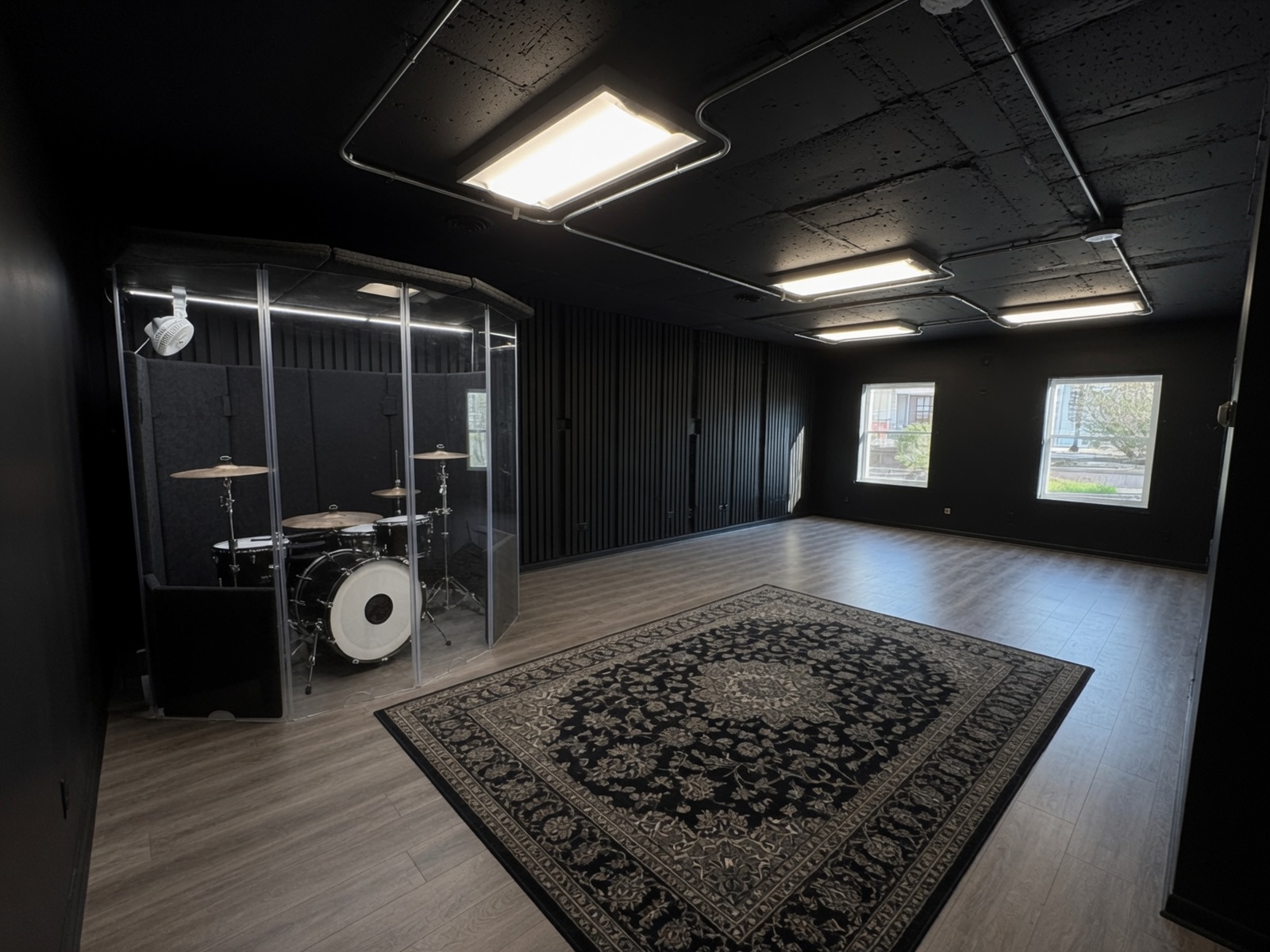 Fracture rehearsal room with drum booth, acoustic treatment, and open band floor